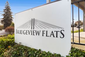 Tacoma apartment for rent - A white sign with the words "Bridgeview Flats" and a logo of a bridge.