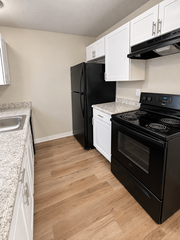 Lakewood apartment for rent - A black stove top oven sits next to a white dishwasher in a kitchen.