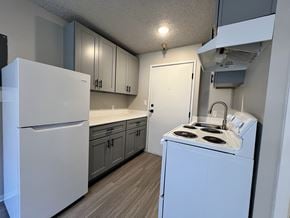 Seattle apartment for rent - A kitchen with a white fridge, white stove, and white cabinets.