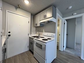 Seattle apartment for rent - A small kitchen with a white stove and cabinets.