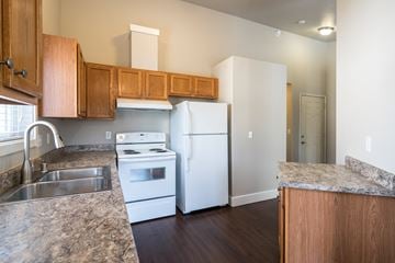 Lacey apartment for rent - a kitchen with white appliances and wooden cabinets and granite counter tops