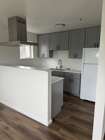 Everett apartment for rent - A kitchen with a white counter and grey cabinets.