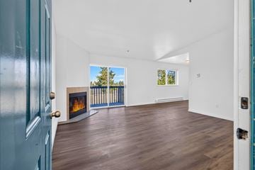 Everett apartment for rent - A room with a fireplace and a view of trees outside the window.