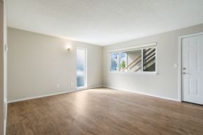 Sumner apartment for rent - A room with wooden floors and a window showing a staircase outside.