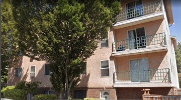 Seattle apartment for rent - A tree in front of a building with a balcony.