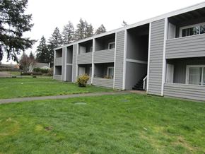 Lakewood apartment for rent - A grassy area in front of a building with a tree to the left.