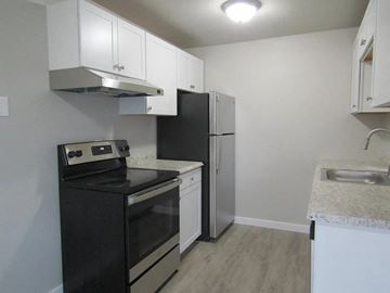 Lakewood apartment for rent - A kitchen with black appliances and white cabinets.