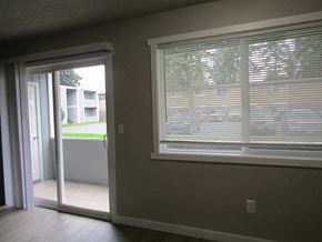 Lakewood apartment for rent - A room with a sliding glass door and a window with blinds.