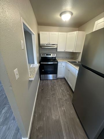 Lakewood apartment for rent - A kitchen with a stove top oven and a refrigerator.