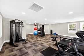 Lacey apartment for rent - A well-equipped home gym with a treadmill, exercise ball, and weight rack.
