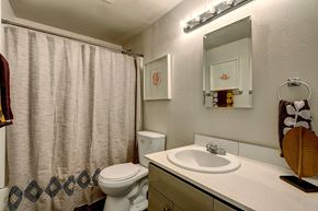 Tacoma apartment for rent - A bathroom with a toilet, sink, and shower curtain.