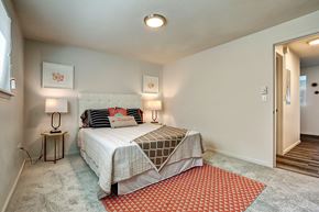 Tacoma apartment for rent - A bedroom with a bed, two lamps, and a rug.