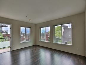 Seattle apartment for rent - Empty living room with a wood floor and three windows  at Charbonneau Apartments in Seattle, WA 98101