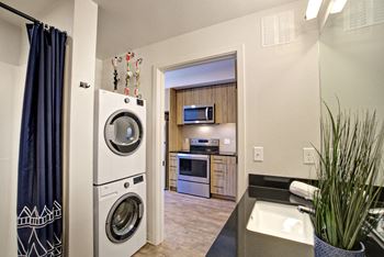 A modern laundry room with a washer and dryer stacked on top of each other