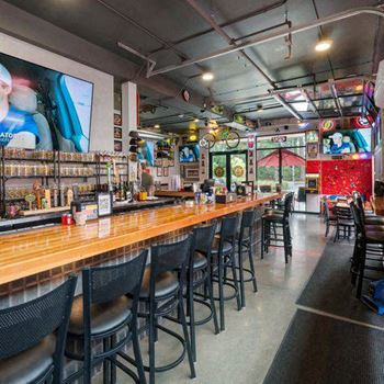 A bar with black chairs and a wooden counter