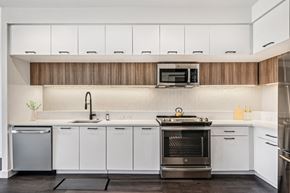 Washington apartment for rent - A modern kitchen with white cabinets and a wooden backsplash.