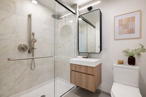 New Rochelle apartment for rent - A modern bathroom with a marble tile shower and a wooden vanity.