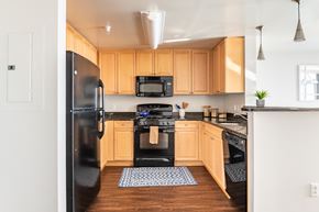 North Bethesda apartment for rent - A kitchen with wooden cabinets and black appliances.