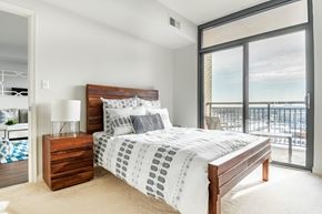 North Bethesda apartment for rent - A bedroom with a large bed and a view of the city.