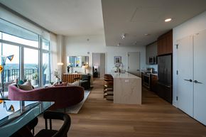 New Rochelle apartment for rent - A modern kitchen with a marble island and a living area with a sofa.