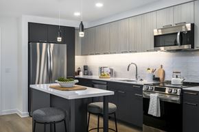 North Bethesda apartment for rent - A modern kitchen with a stainless steel refrigerator and a white island.