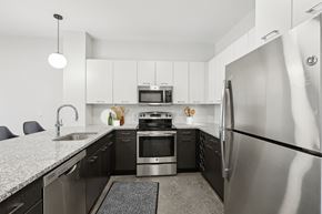 Everett apartment for rent - A modern kitchen with a stainless steel refrigerator and black countertops.