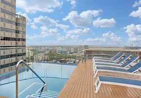 Philadelphia apartment for rent - A rooftop pool with lounge chairs and a view of the city.