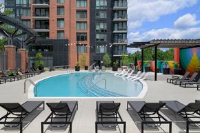 North Bethesda apartment for rent - A pool surrounded by black chairs and a building in the background.