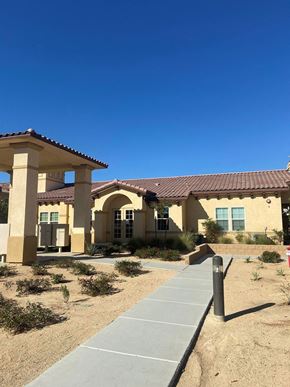 Hesperia apartment for rent - A building with a red tile roof and a covered walkway in front.at The Villas 55+ II Hesperia, Hesperia, CA 92660  
