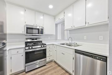 Riverside apartment for rent - A modern kitchen with white cabinets and stainless steel appliances.