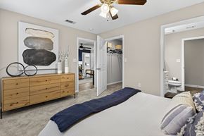 Hattiesburg apartment for rent - A bedroom with a large bed and a wooden dresser.