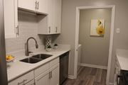 Laurel apartment for rent - a kitchen with white cabinets and a sink and a door to a bathroom  at Laurelwood Apartment Homes, Laurel, Mississippi