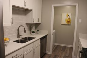 Laurel apartment for rent - a kitchen with white cabinets and a sink and a door to a bathroom  at Laurelwood Apartment Homes, Laurel, Mississippi