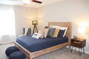 Laurel apartment for rent - a bedroom with a bed and a ceiling fan  at Laurelwood Apartment Homes, Laurel, Mississippi