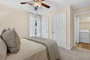 Ocean Springs apartment for rent - A bedroom with a bed, a ceiling fan, and a small refrigerator.