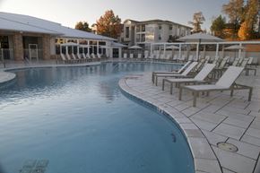 Oxford apartment for rent - A large outdoor swimming pool with sun loungers and a building in the background. at The Azul Apartment Homes, Oxford, Mississippi
