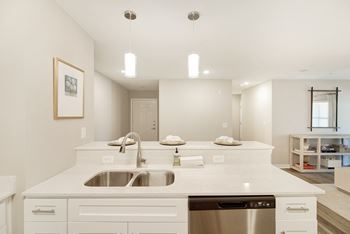 A modern kitchen with a white countertop and stainless steel appliances and dishwasher