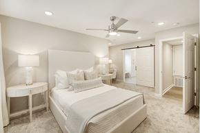 Oxford apartment for rent - a white bedroom with a large bed and a ceiling fan at The Azul Apartment Homes in Oxford, MS