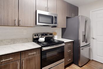 A kitchen with stainless steel appliances and wooden cabinets