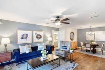 A living room with a blue couch and a ceiling fan