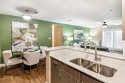 Starkville apartment for rent - a kitchen with a sink and a dining room with a table and chairs at Crossgates Apartment Homes, Mississippi 39759