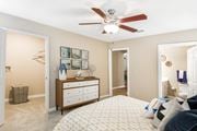 Starkville apartment for rent - a bedroom with a large bed and a ceiling fan at Crossgates Apartment Homes, Starkville, MS 39759