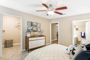 Starkville apartment for rent - a bedroom with a large bed and a ceiling fan at Crossgates Apartment Homes, Starkville, MS 39759