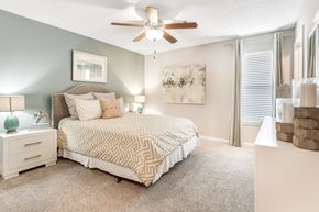 Starkville apartment for rent - a bedroom with a bed and a ceiling fan at Avalon Apartments Starkville, MS