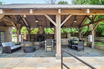 A patio with a fireplace and chairs