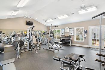 A spacious gym with a variety of equipment including treadmills, weights, and exercise machines