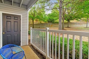 A blue chair sits on a porch with a white railing
