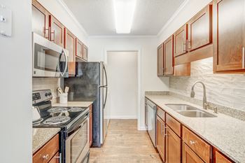 A kitchen with wooden cabinets and a black refrigerator