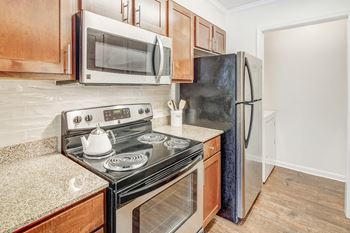 A kitchen with a black stove top oven and a black refrigerator