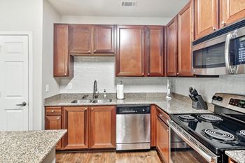 Kitchen with wooden cabinets and a granite countertop and stainless steel dishwasher